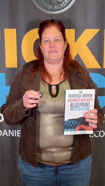 Attendee with Jesse Wood's book at Sticker Shock International Speaking Academy